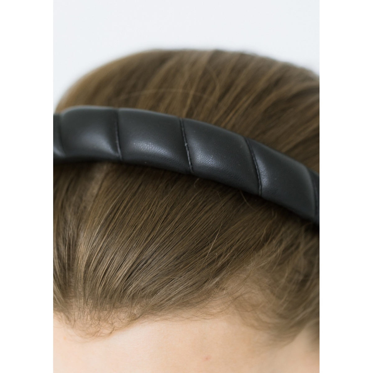 The Hadley Headband is made in New York from genuine leather and designed to stay firmly in place while ensuring comfort. We recommend storing headbands in their dust bag while not in use. Avoid contact with water