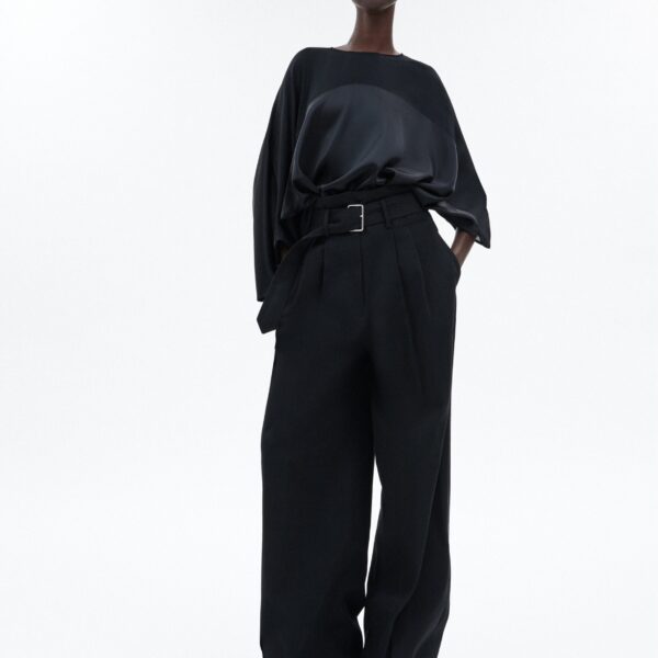 draped design features a high-neck collar and a cascading silhouette