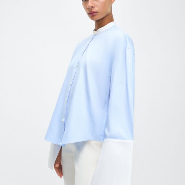 with a subtle slit near the cuffs for added detail. Made from the highest quality cotton and featuring diamond monogram mother of pearl buttons down the center front