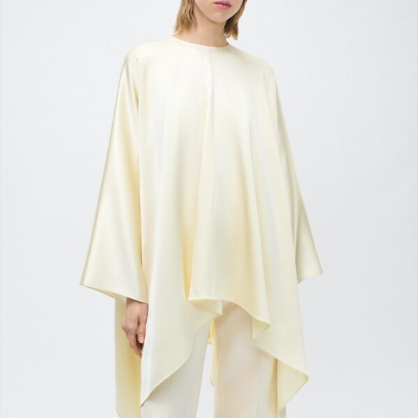 fluid drape in a delicate cream hue. Featuring a detachable scarf for versatile styling options. The clean lines and elegant shape make it a statement piece