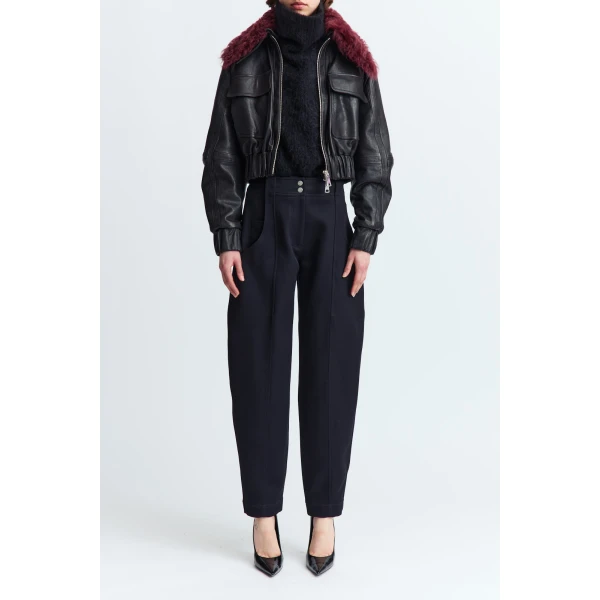 designed with a double zip closure and a cinched waist for subtle structure. It features two oversized flap pockets at the chest and a detachable sheerling collar that adds warmth and texture.