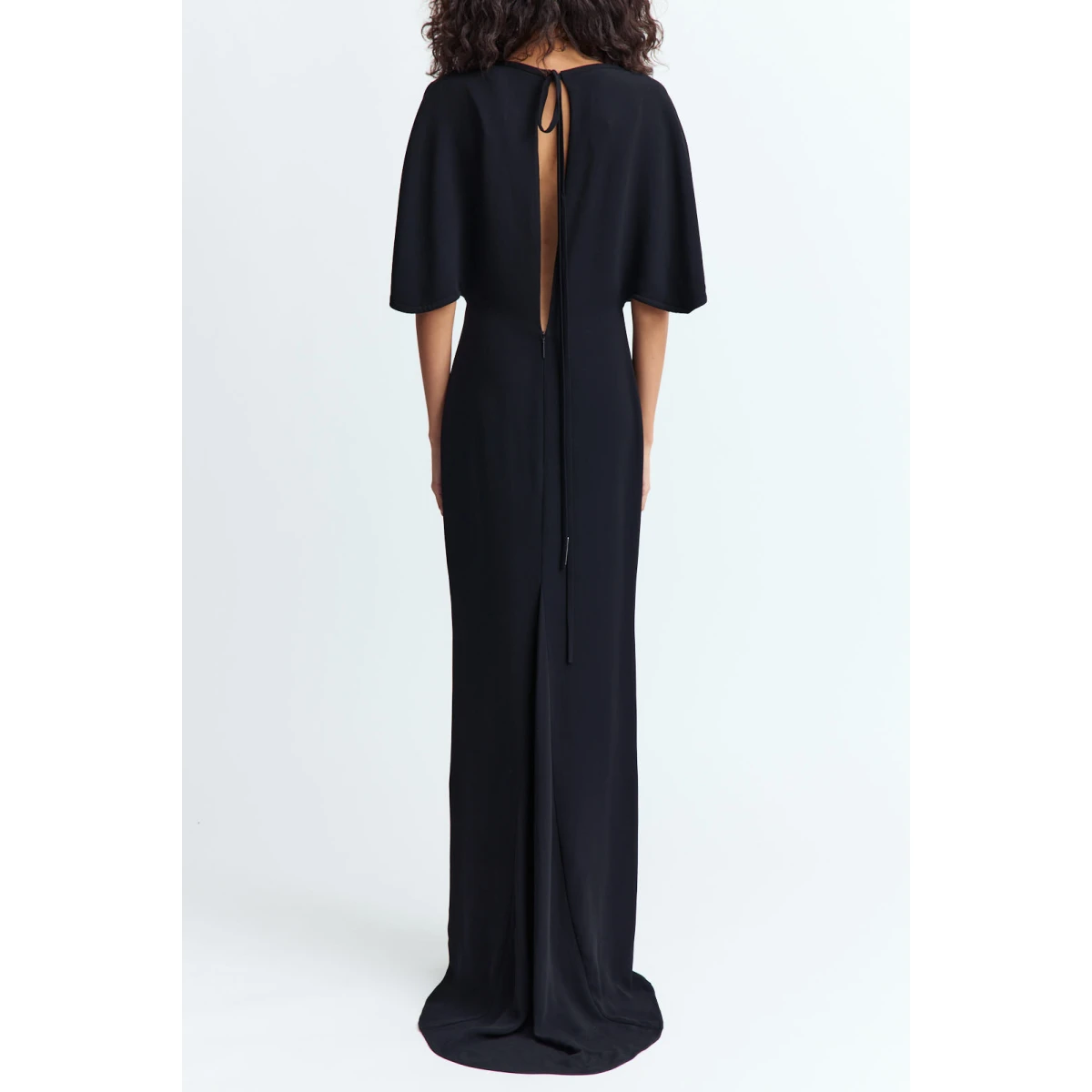 cape like sleeves that fall softly over the shoulders and a tapered waist that defines the form.