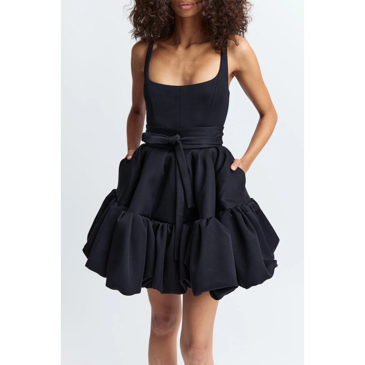 designed to contour the body. It features a scoop neckline with slender straps