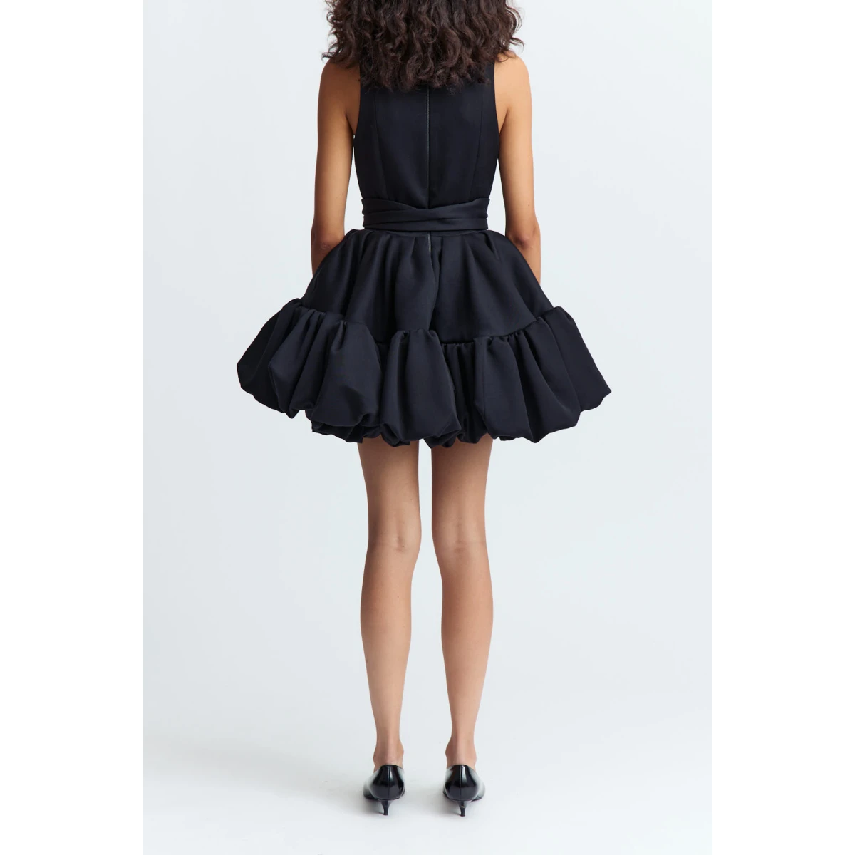 and a voluminous bubble peplum skirt that brings sculptural shape and a playful edge to the look.