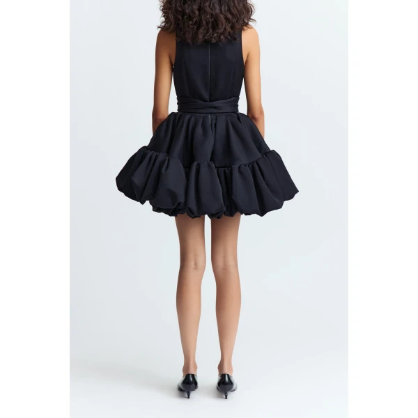 and a voluminous bubble peplum skirt that brings sculptural shape and a playful edge to the look.