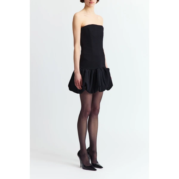 it flares into a dramatic bubble peplum skirt that adds bold volume and contrast to its clean