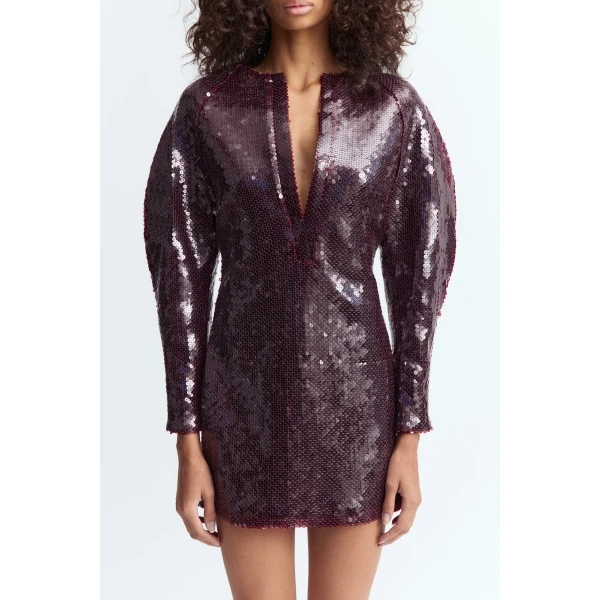 designed to catch the light with subtle intensity. It features a narrow plunge split at the front and sculptural long sleeves shaped with volume through the shoulders and upper arms before tapering neatly at the wrists.