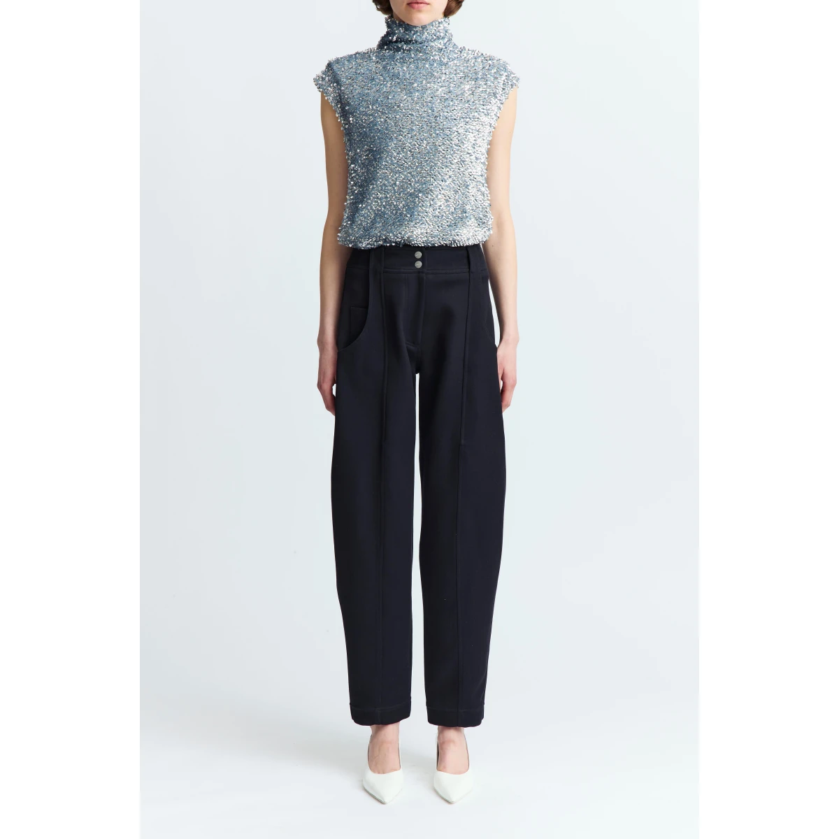 lending structure and elongation to the silhouette. It features four pockets - two at the front and two at the back - along with three buttons at the rear and belt loops at the waist. A refined take on classic tailoring with a sculptural twist.