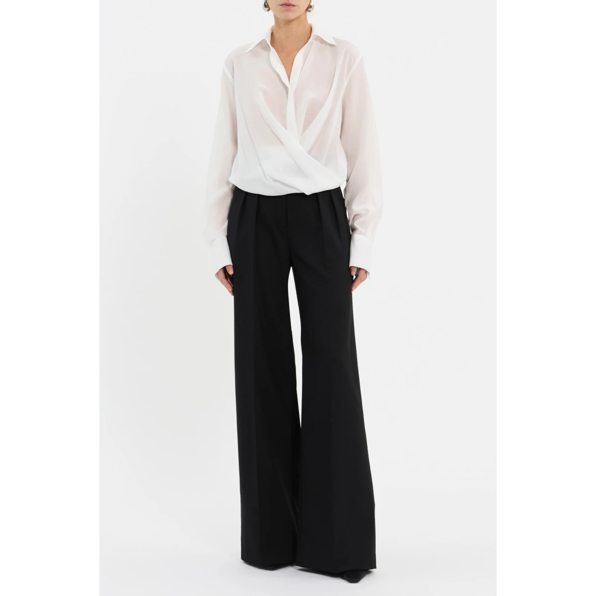 complemented by a concealed placket and long sleeves finished with wide cuffs. French seams and double-turn hems elevate the polished design