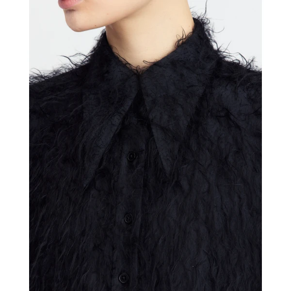 It features an exaggerated collar and a fluid drape