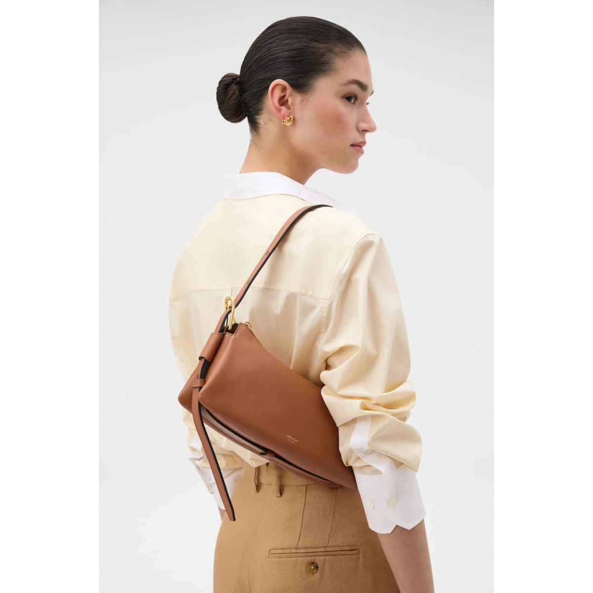Profile view of model wearing the Oroton CALI BAGUETTE in AMBER and Premium smooth leather for Women