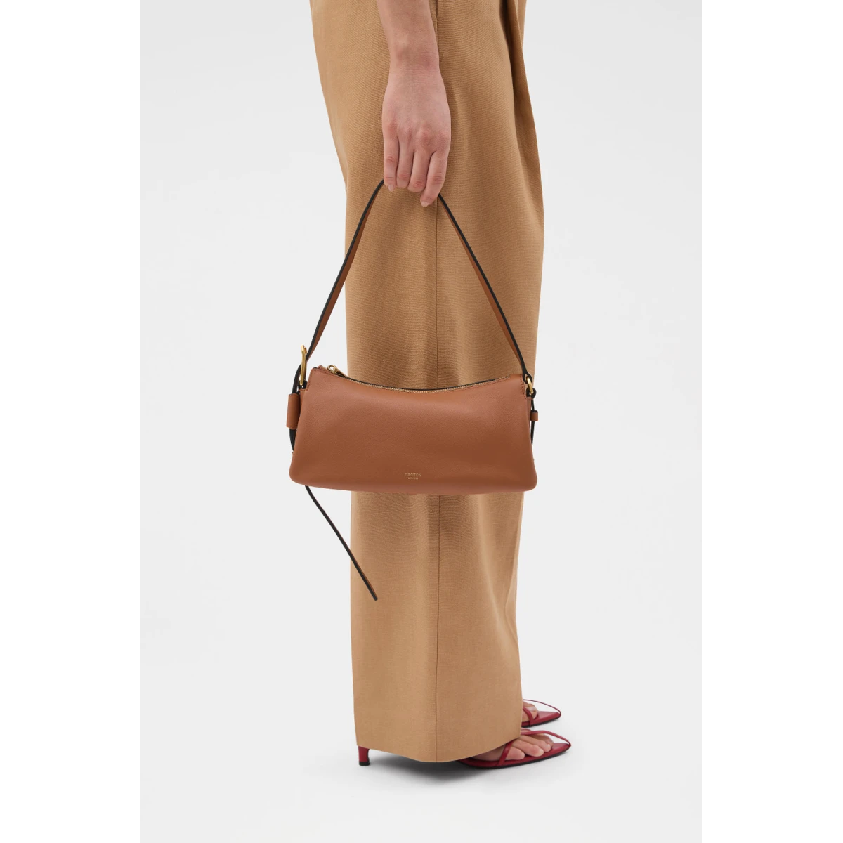 Profile view of model wearing the Oroton CALI BAGUETTE in AMBER and Premium smooth leather for Women