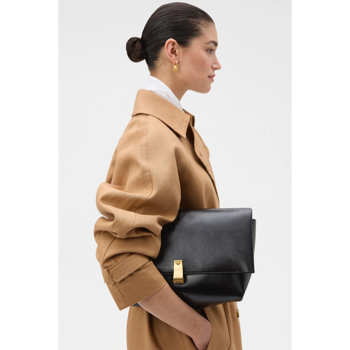 Profile view of model wearing the Oroton ETTA LARGE CLUTCH in DARK CHOCOLATE and Premium crackle leather for Women