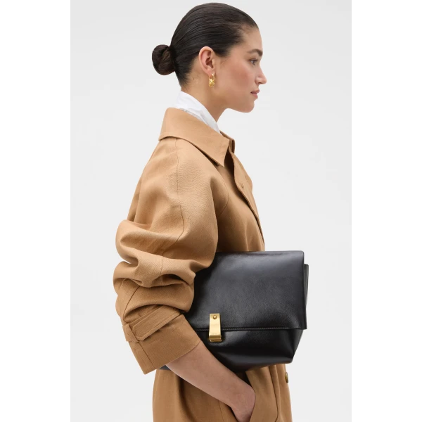 Profile view of model wearing the Oroton ETTA LARGE CLUTCH in DARK CHOCOLATE and Premium crackle leather for Women