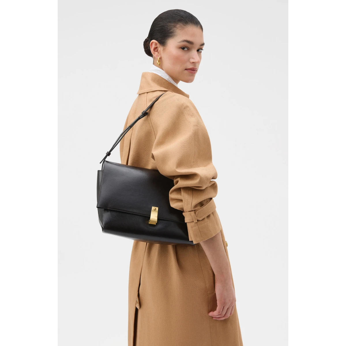 Profile view of model wearing the Oroton ETTA LARGE CLUTCH in DARK CHOCOLATE and Premium crackle leather for Women
