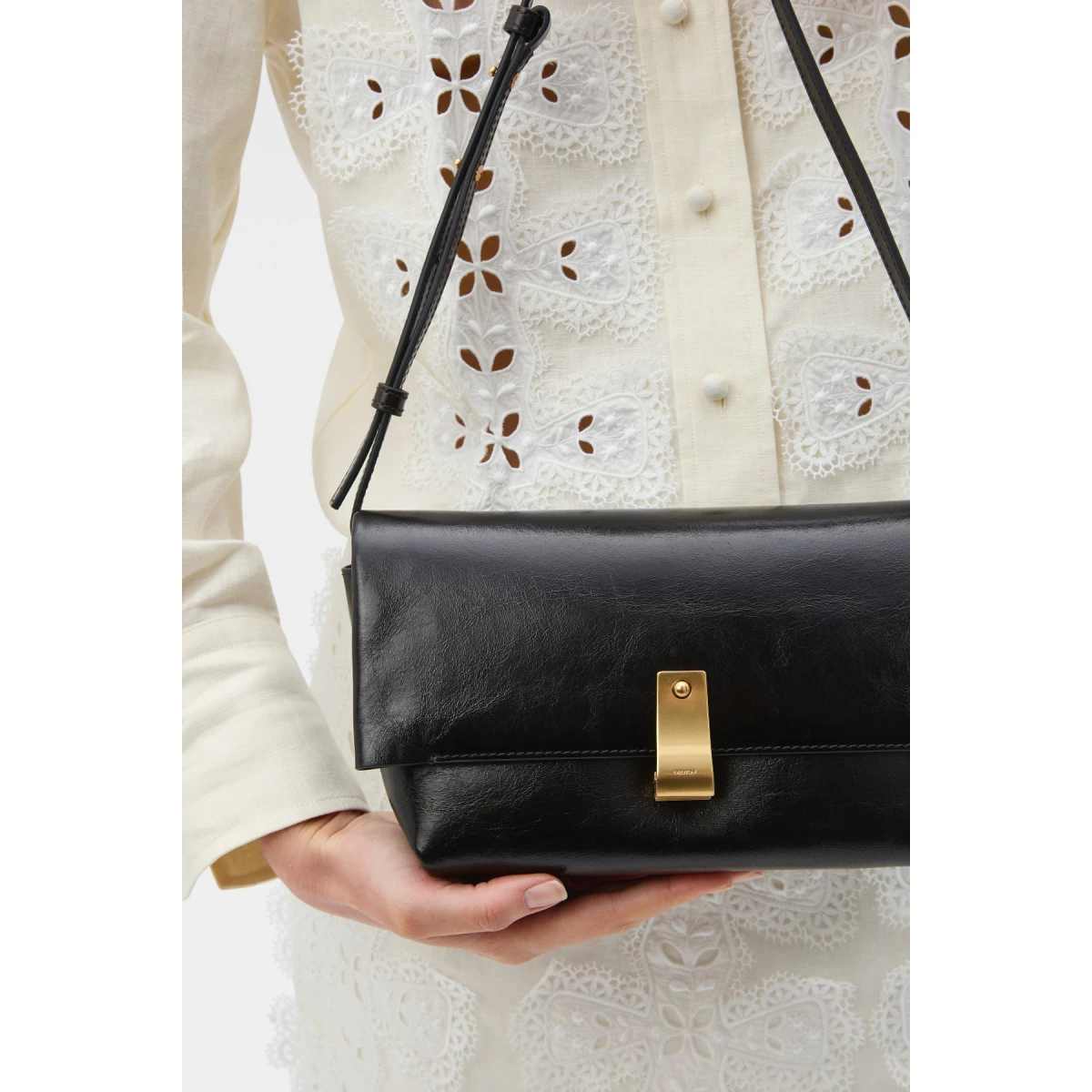 Profile view of model wearing the Oroton ETTA MEDIUM CLUTCH in DARK CHOCOLATE and Premium crackle leather for Women