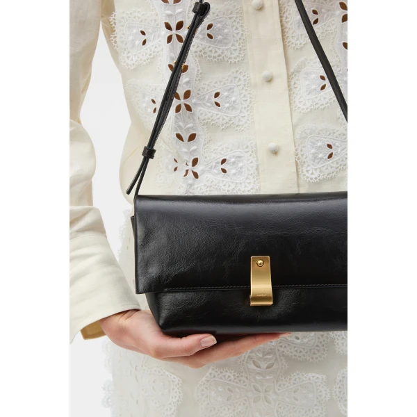 Profile view of model wearing the Oroton ETTA MEDIUM CLUTCH in DARK CHOCOLATE and Premium crackle leather for Women