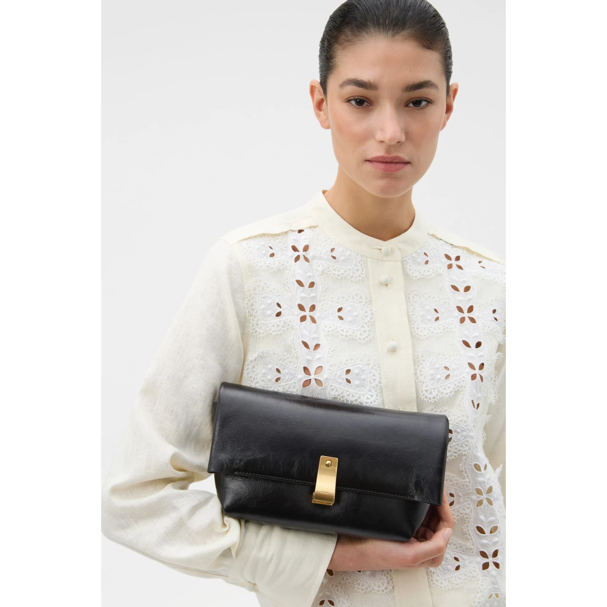 Profile view of model wearing the Oroton ETTA MEDIUM CLUTCH in DARK CHOCOLATE and Premium crackle leather for Women