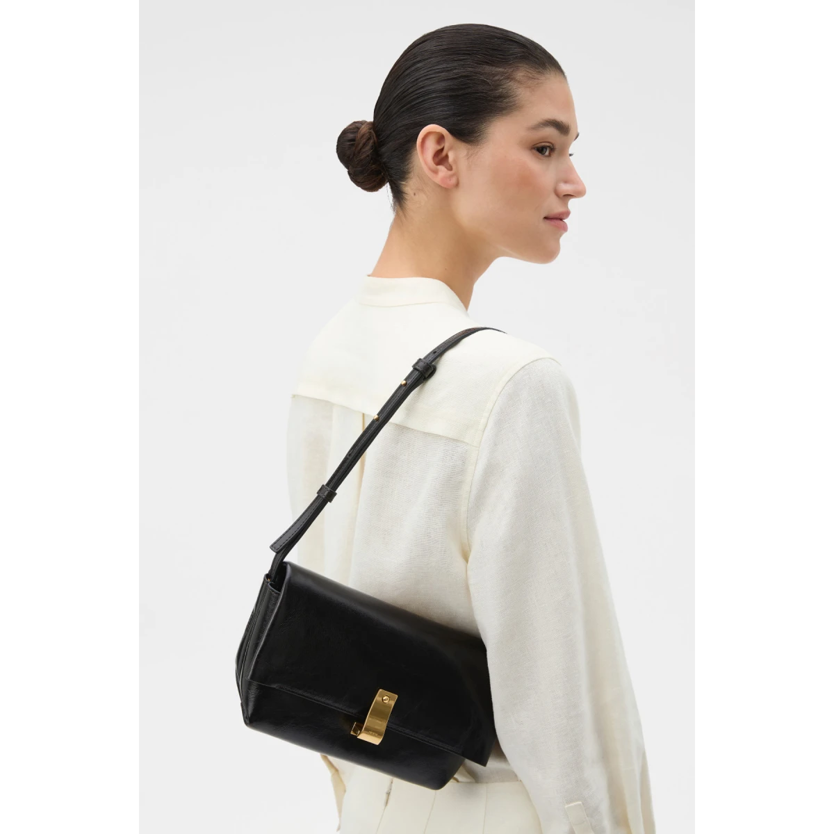 Profile view of model wearing the Oroton ETTA MEDIUM CLUTCH in DARK CHOCOLATE and Premium crackle leather for Women