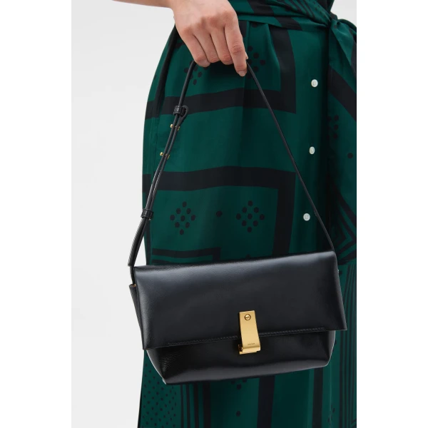 Profile view of model wearing the Oroton ETTA MEDIUM CLUTCH CRACKLE in BLACK and Premium crackle leather for Women