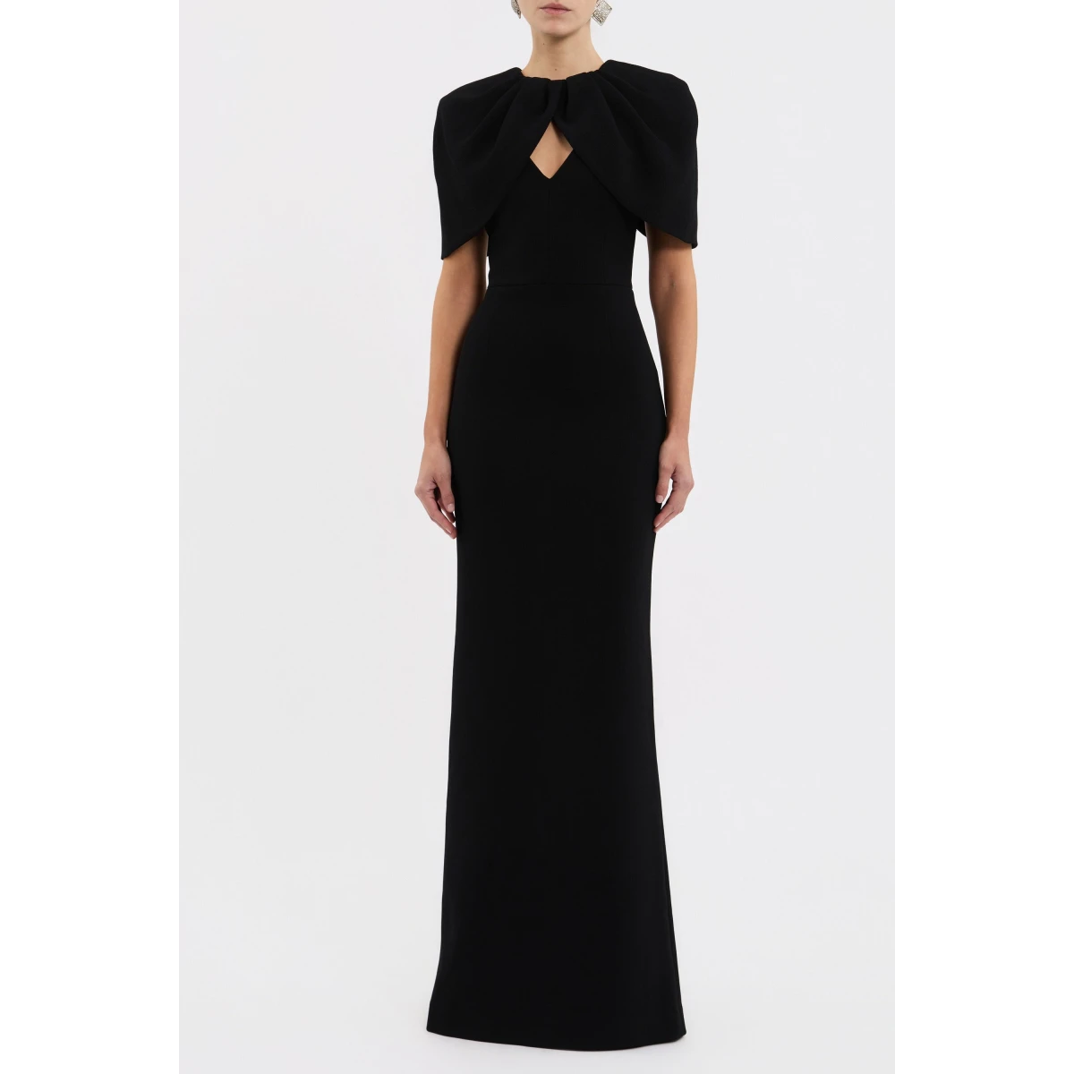 it features a striking draped cape overlay that harmonises with the V neckline and fitted bodice