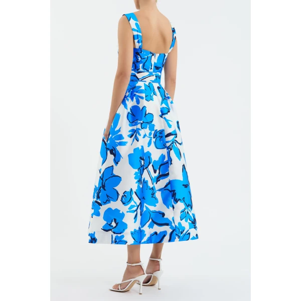 elevated by a cowl bust and thick straps. Side seam pockets and a self-belt enhance the graceful circular midi skirt