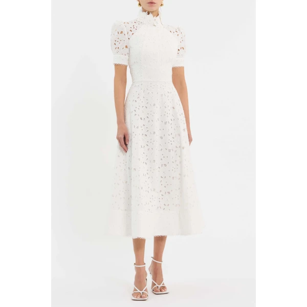 tailored from broderie anglaise. Its floral trim neckline seamlessly harmonises with the fitted bodice