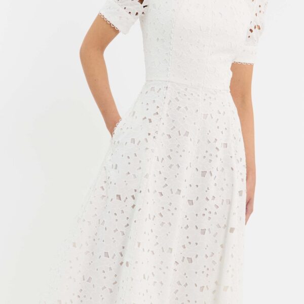 is detailed with scallop trims for refined charm and enhanced with side pockets for added convenience. Fully lined and secured with an invisible zip fastening