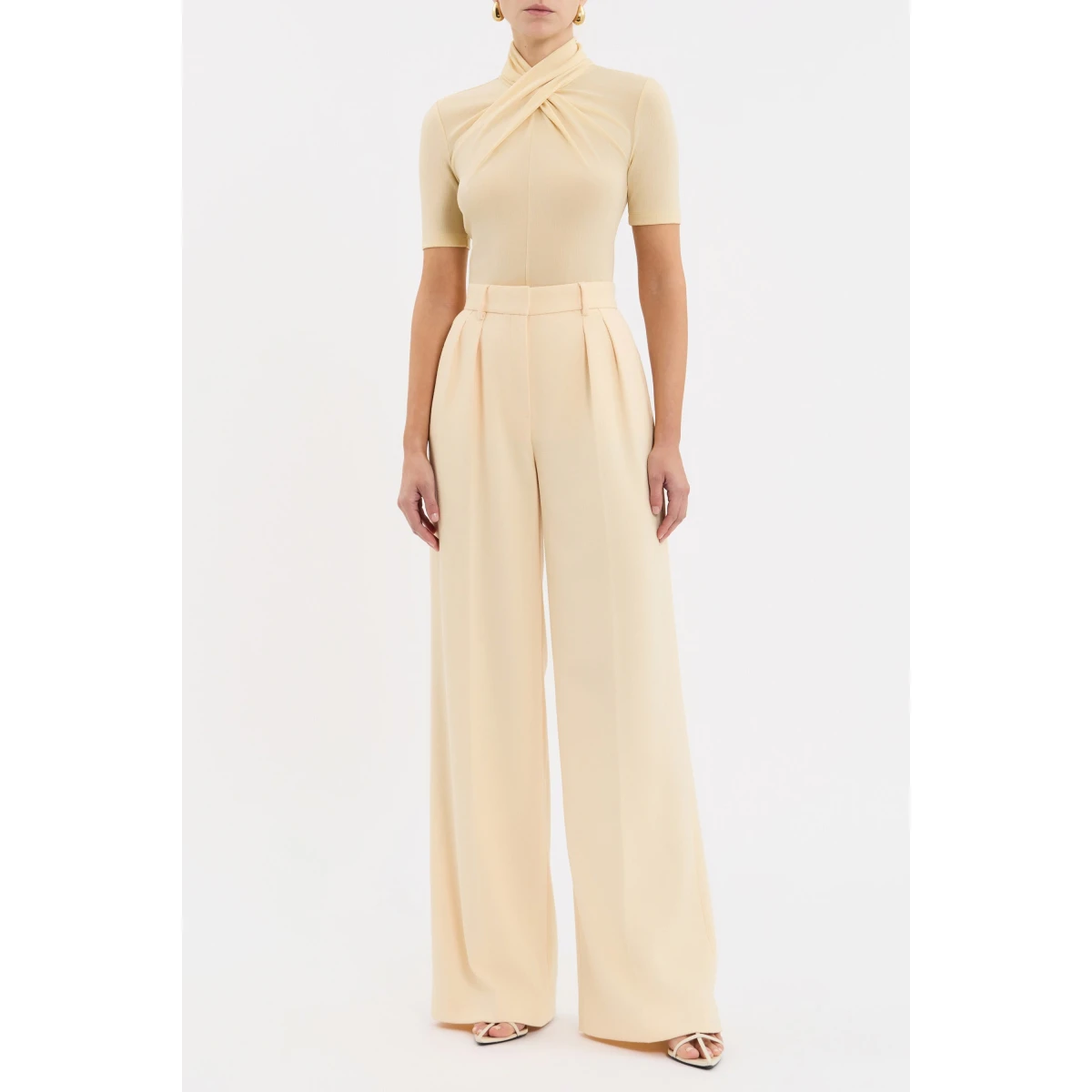 its fitted silhouette is elevated by a high twist neckline and short sleeves for a flattering finish. A low-waisted hem and invisible zip fastening at the back lend a refined