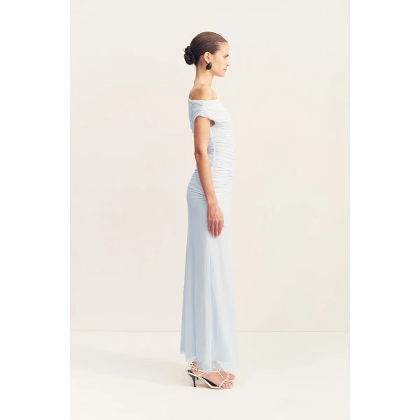 Asymmetrical off shoulder maxi dress in sky in a sheer mesh.