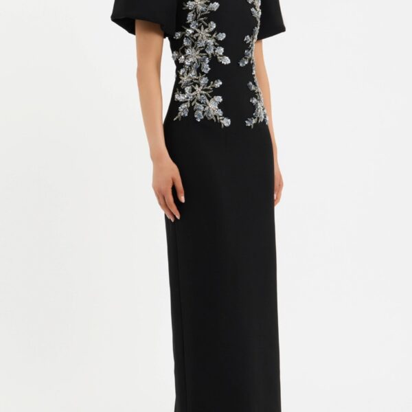 its short puff sleeves and fitted bodice sculpt a sophisticated shape