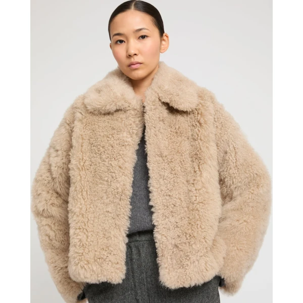 Woman wearing Yves Salomon shearling fur coat – luxury outerwear at Coveti