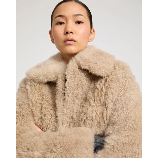 Woman wearing Yves Salomon shearling fur coat – luxury outerwear at Coveti
