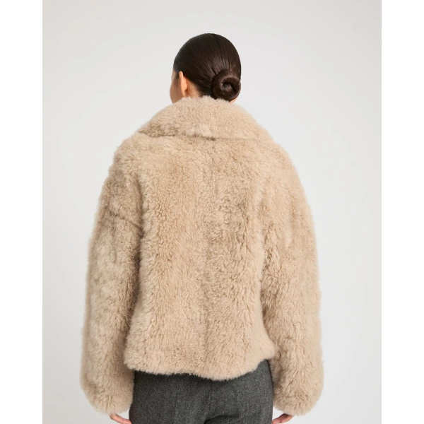Woman wearing Yves Salomon shearling fur coat – luxury outerwear at Coveti