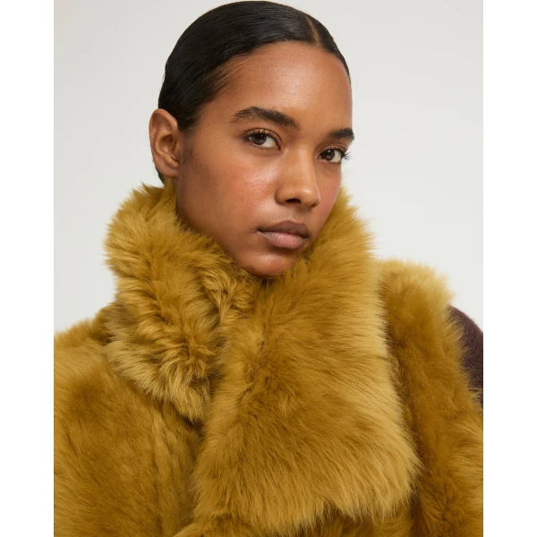 Woman wearing Yves Salomon shearling fur coat – luxury outerwear at Coveti