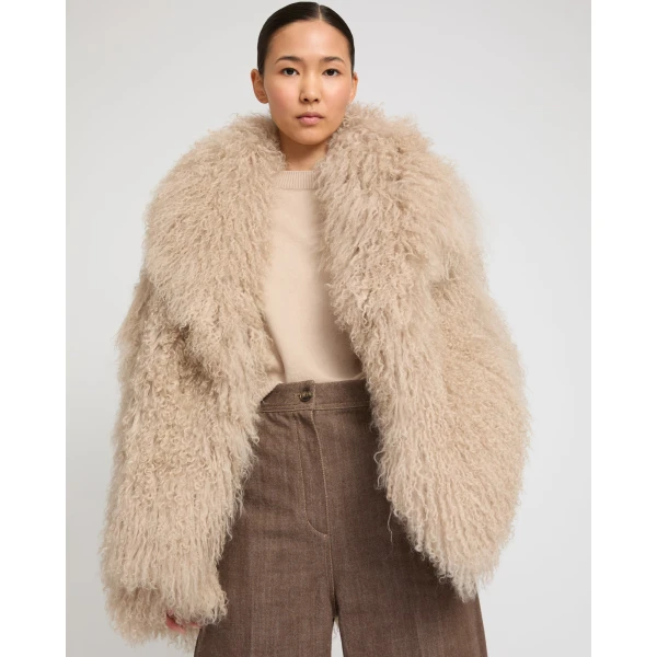 Woman wearing Yves Salomon shearling fur coat – luxury outerwear at Coveti