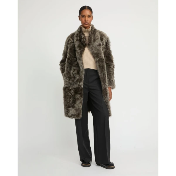 Woman wearing Yves Salomon shearling fur coat – luxury outerwear at Coveti