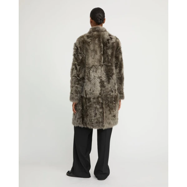 Woman wearing Yves Salomon shearling fur coat – luxury outerwear at Coveti