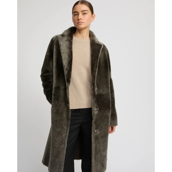 Woman wearing Yves Salomon shearling fur coat – luxury outerwear at Coveti