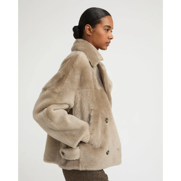 Woman wearing Yves Salomon shearling fur coat – luxury outerwear at Coveti