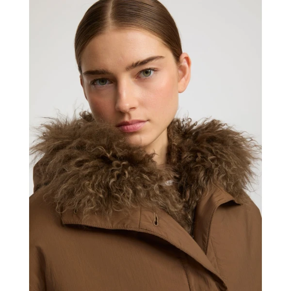 Woman wearing Yves Salomon shearling fur coat – luxury outerwear at Coveti
