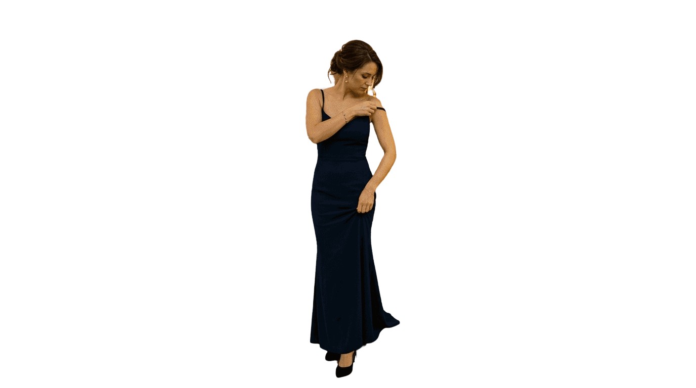 Una donna sistema con eleganza il suo abito da sera mentre scende la maestosa scalinata.