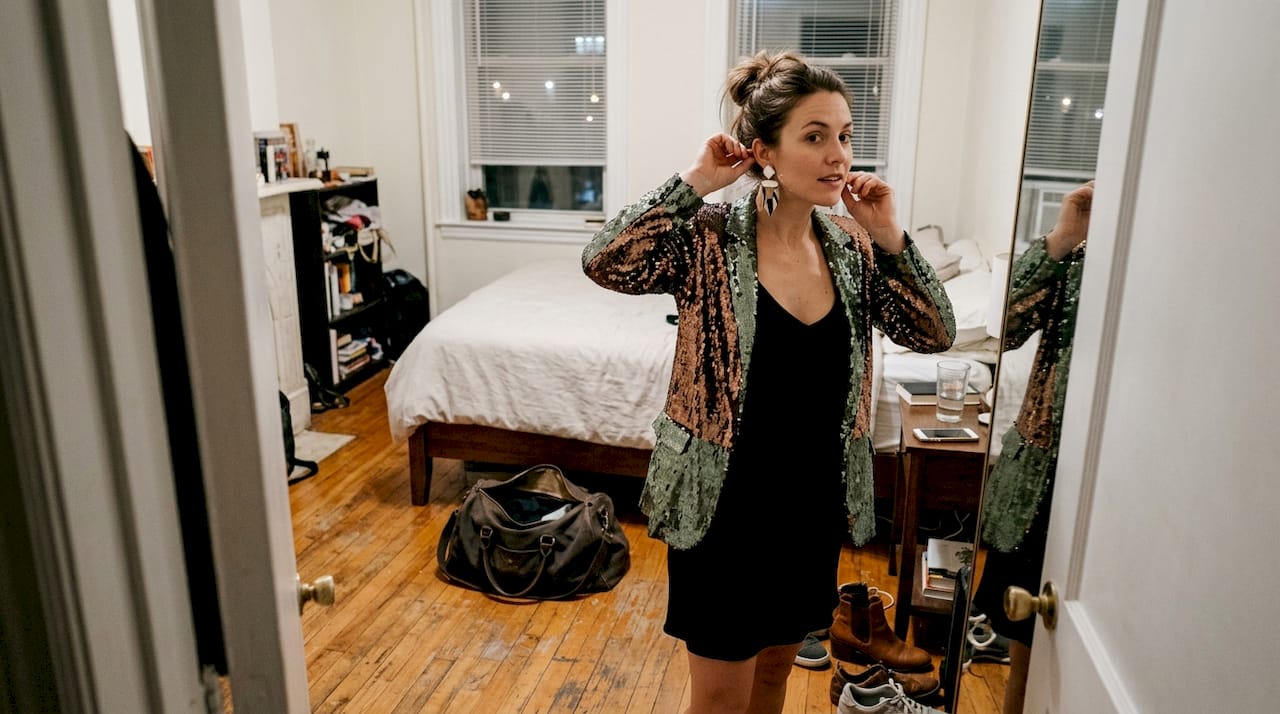 Chez elle, une femme peaufine sa tenue audacieuse pour la soirée.
