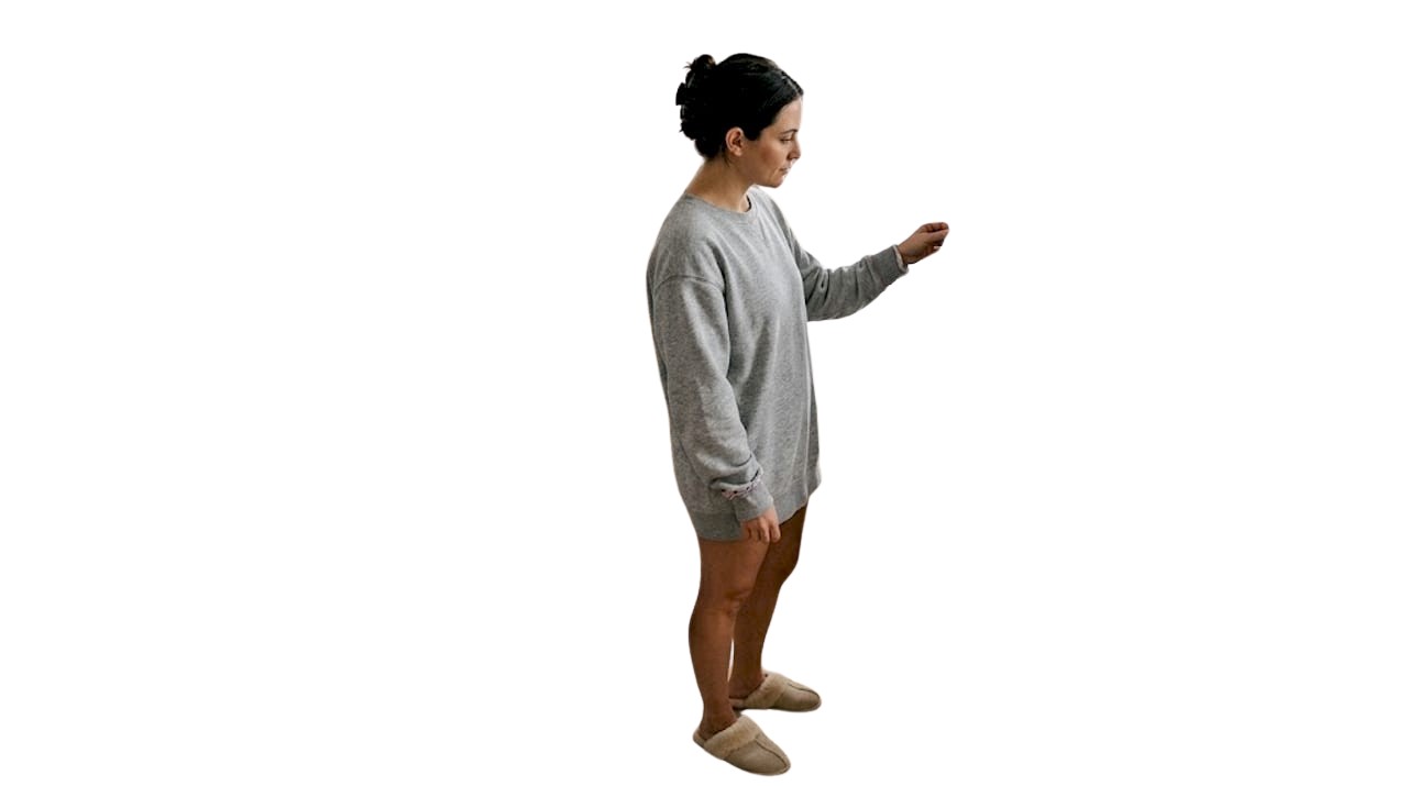 Eine Frau steht im Schlafzimmer vor dem Spiegel und begutachtet ihr Party-Outfit.