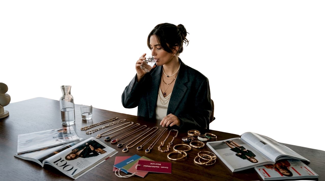 Een vrouw zit aan tafel en sorteert moderne accessoires.