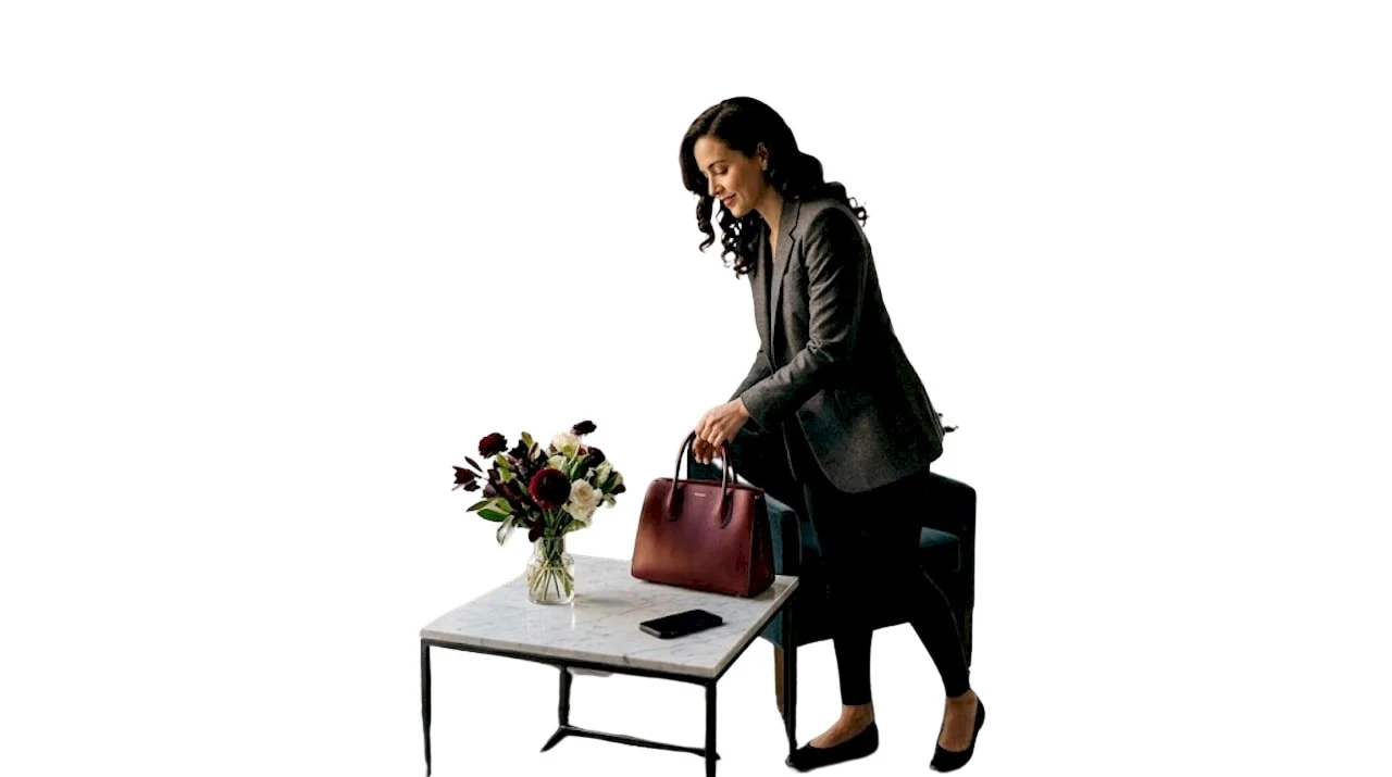 Eine Frau stellt ihre Designer-Handtasche auf die Küchenarbeitsplatte.