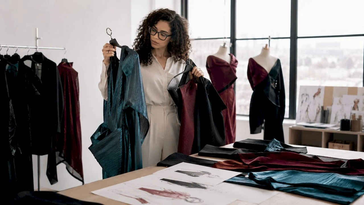 Joven diseñadora explora una boutique eligiendo prendas vanguardistas