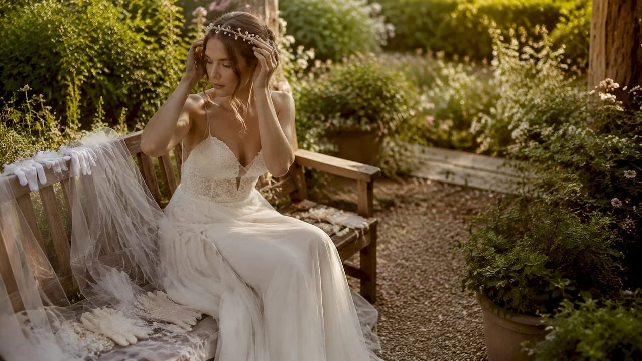 Die Braut richtet ihre Perlenkette zwischen den anderen Hochzeitsaccessoires zurecht.