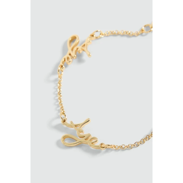 Aje Larissa Cursive Bracelet in Gold | Bracelets | Coveti