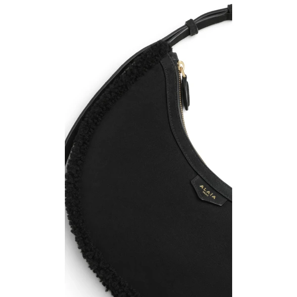 Alaia One Piece Demi Lune Bag in Merino Shearling, Black | Shoulder & Crossbody Bags | Coveti